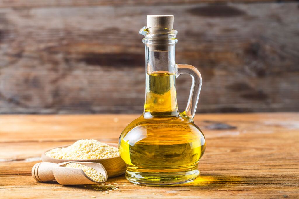 sesame-seeds-and-bottle-with-oil-on-a-old-wooden-table-sesame-oil-oil-in-a-glass-jug-(1)